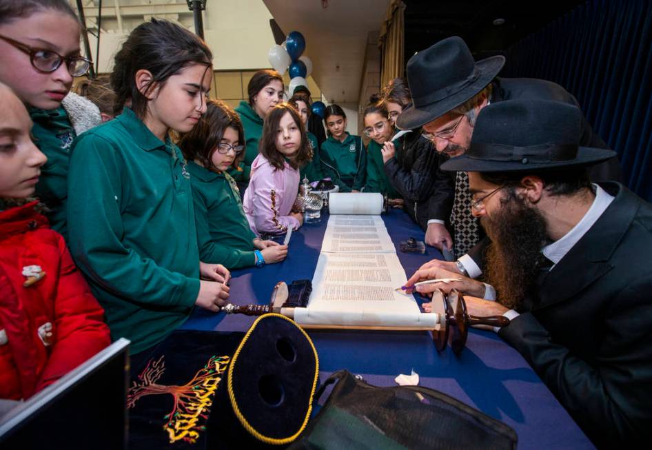 Rabbi Dovid Bressman, bottom right, as Sofer with Rabbi Shea Harlig, above, inscribes the new T ...