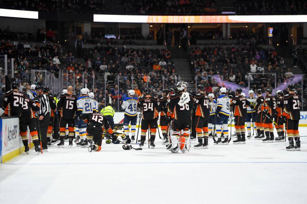 Members of the St. Louis Blues and Anaheim Ducks gather on the ice as Blues defenseman Jay Bouw ...