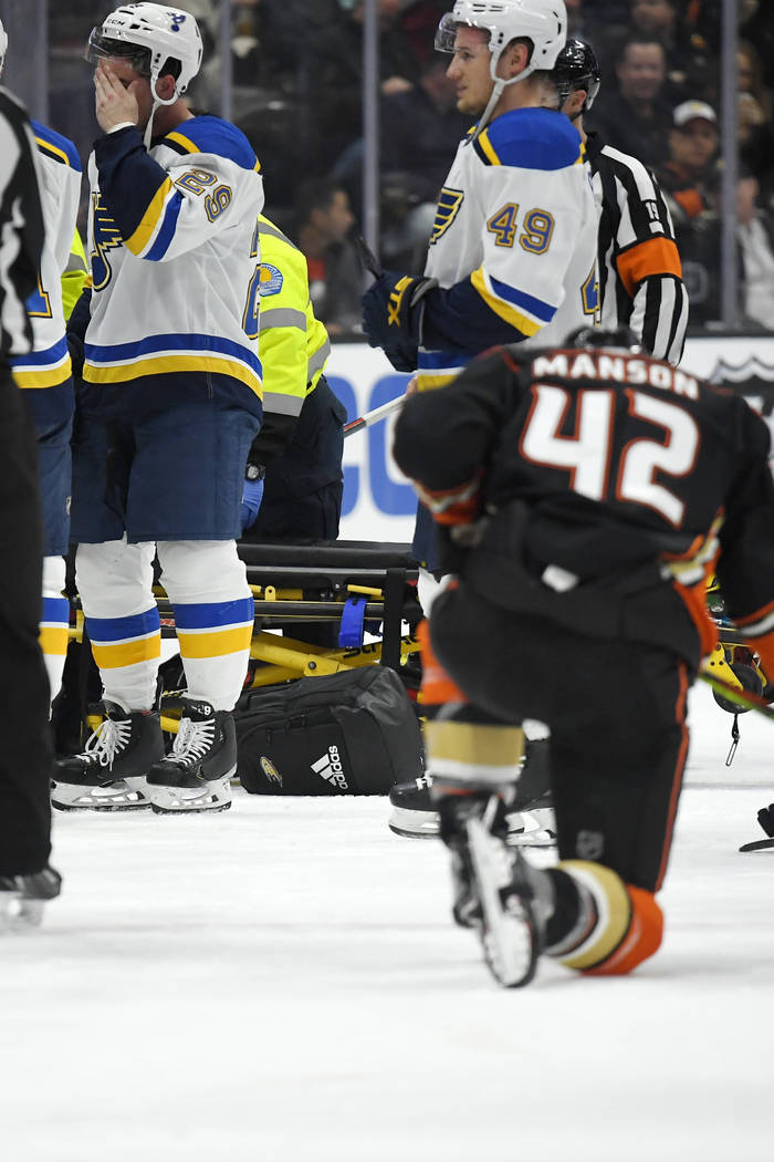 St. Louis Blues defenseman Vince Dunn, left, wipes his faces as Anaheim Ducks defenseman Josh M ...