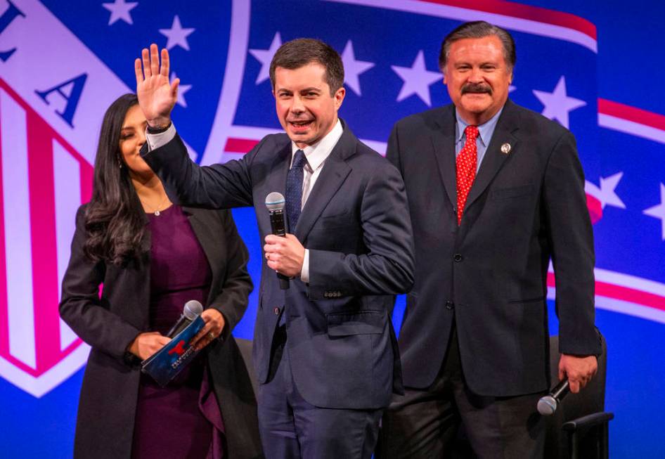 Former South Bend, Ind., Mayor Pete Buttigieg arrives on stage with Leticia Castro and Domingo ...