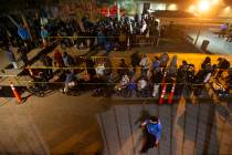 People wait in line to check in and get a sleeping mat at the Courtyard Homeless Resource Cente ...