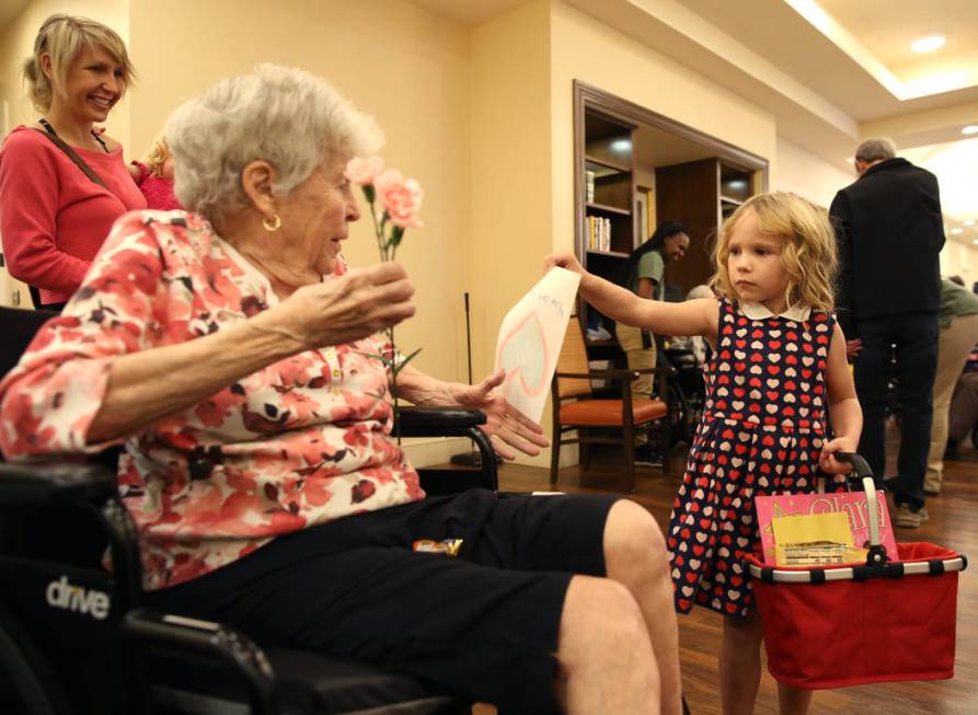 Katerina Smith, 4, hands out Valentine's flowers and a card to Elly Fanizz at Poet's Walk, a me ...