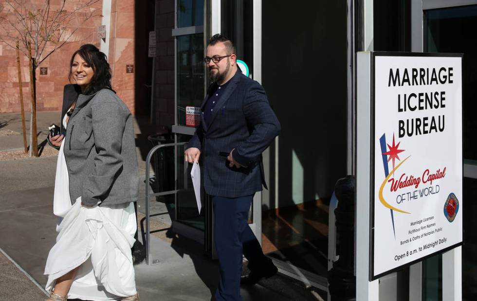 Marylyn Barnett, 39, and Trevor Pennock, 35, both of Nebraska, leave the Marriage License Burea ...