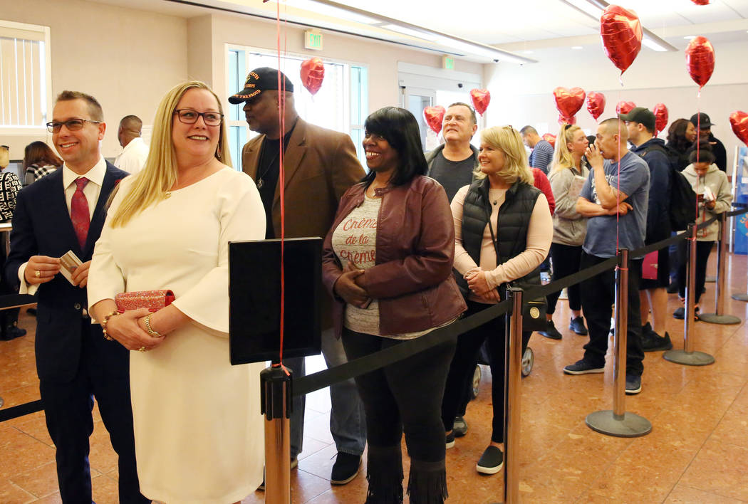 People, including Marylyn Barnett and Trevor Pennock, front, both of Nebraska, wait in line to ...