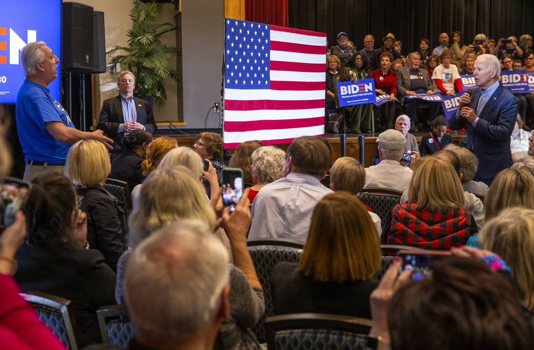 Former Vice President Joe Biden, right, looks to a man disrupting his talk during an early vote ...