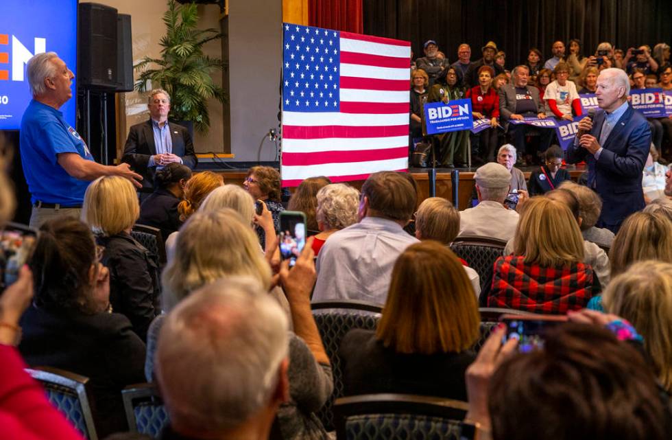 Former Vice President Joe Biden, right, looks to a man disrupting his talk during an early vote ...