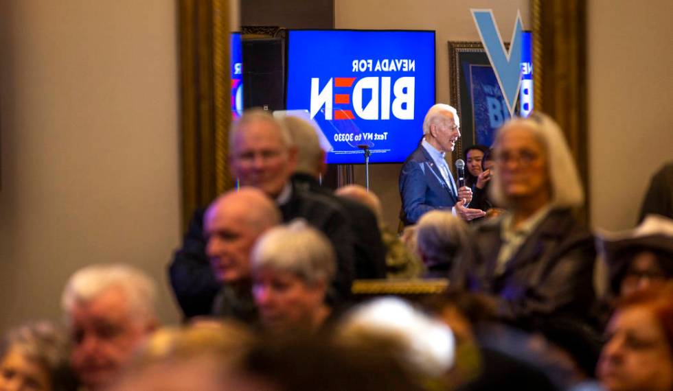 Former Vice President Joe Biden is reflected in a mirror as he speaks during an early vote even ...