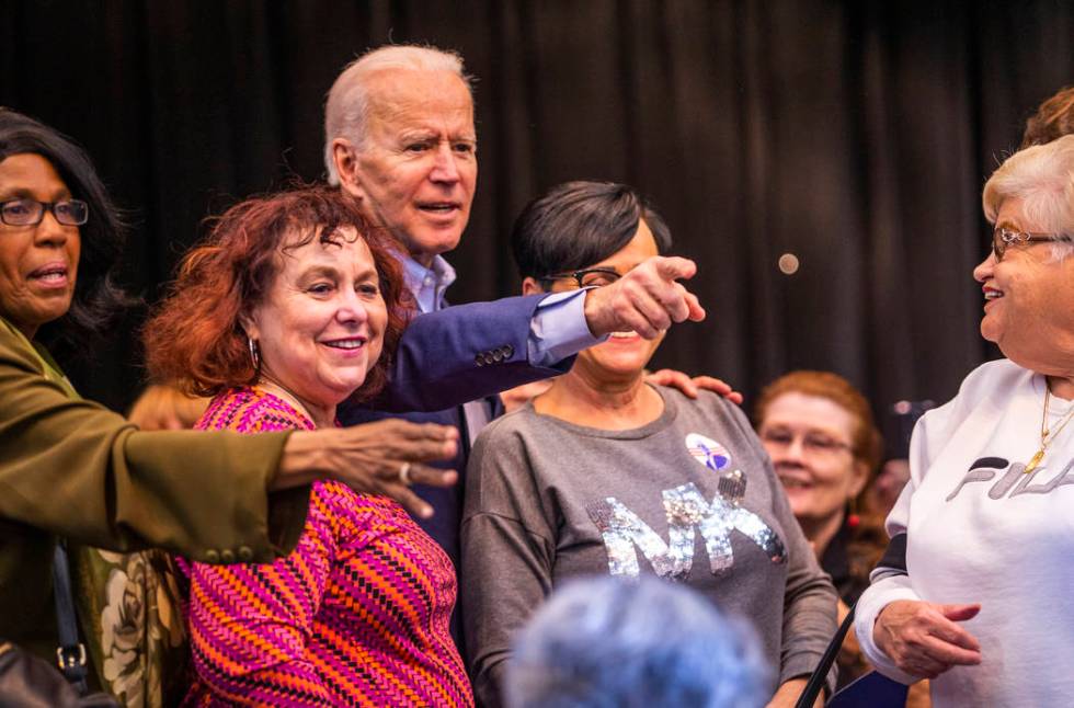 Former Vice President Joe Biden joins a group photo with attendees following an early vote eve ...