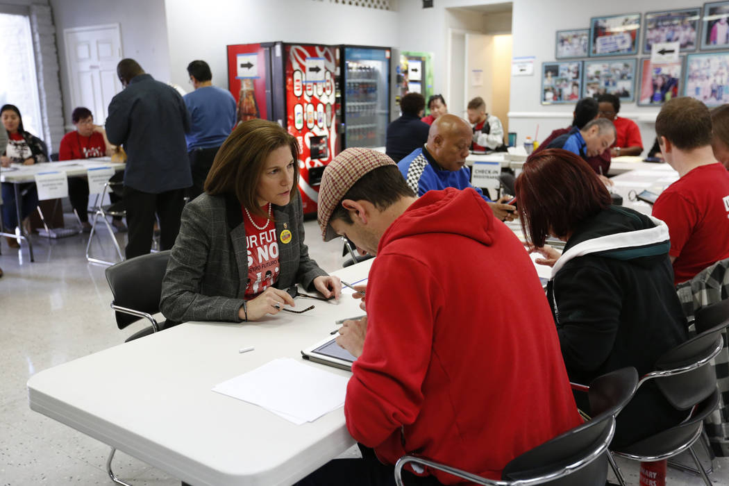 Sen. Catherine Cortez Masto, D-Nev., left, is seen at a check-in table on the first day of earl ...