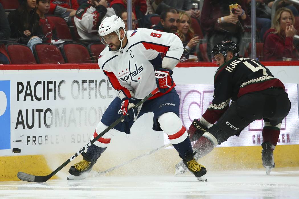 Washington Capitals left wing Alex Ovechkin (8) tries to control the puck in front of Arizona C ...