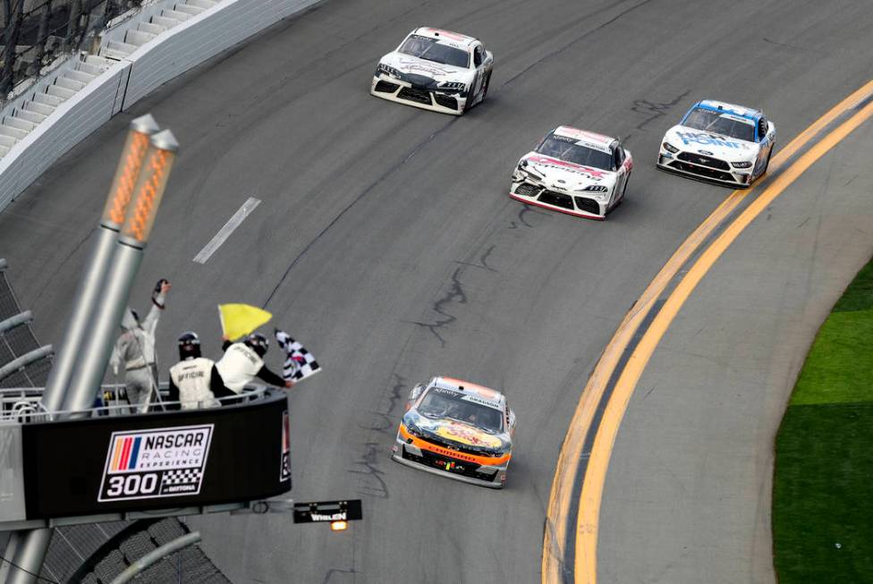 Noah Gragson, front, takes the checkered flag to win the NASCAR Xfinity series auto race at Day ...