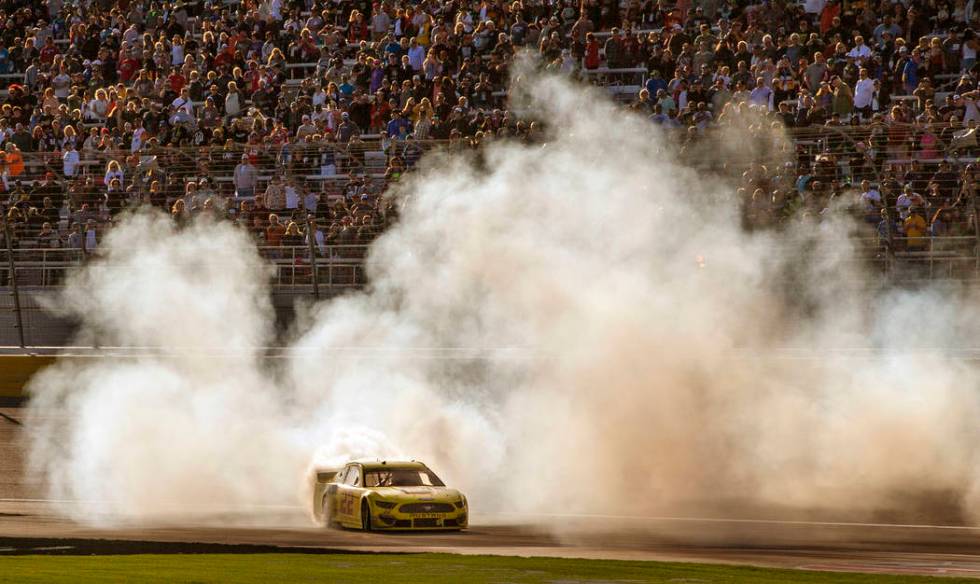 Joey Logano (22) celebrates with a burn out at the finish line following his win in the Pennzoi ...