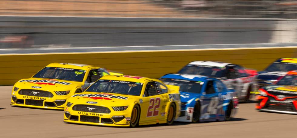 Joey Logano (22, left) is in the thick of things entering turn one during the Pennzoil 400 pres ...