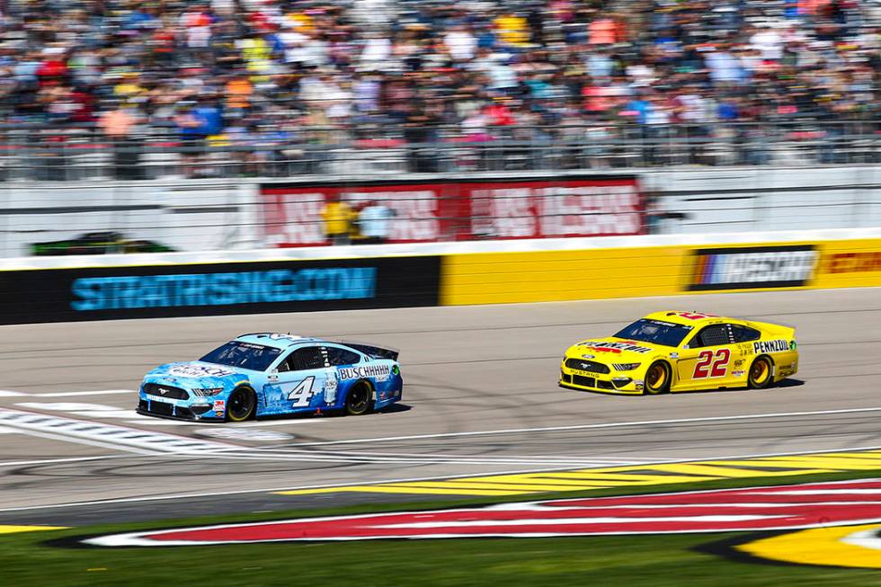 Kevin Harvick (4) and Joey Logano (22) drive during a NASCAR Cup Series auto race at the Las Ve ...