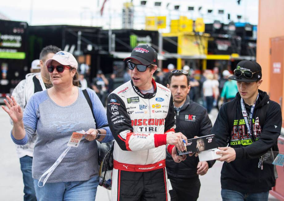 Brad Keselowski, middle, walks in pit row after completing his practice run on Saturday, March ...