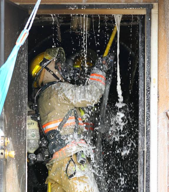 A Las Vegas firefighter battles a house fire at 2417 Howard Drive on Tuesday, Feb. 18, 2020, in ...