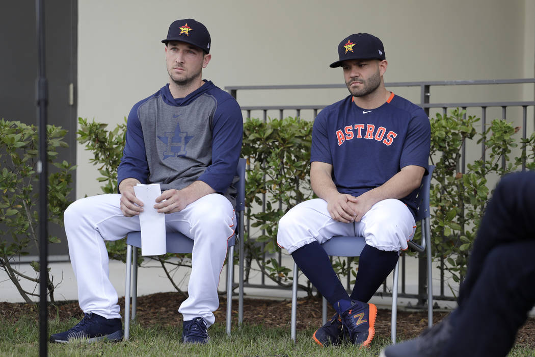 Houston Astros infielder Alex Bregman, left, and teammate Jose Altuve sit in chairs as the wait ...