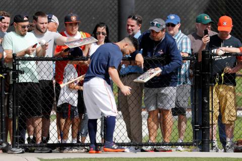 Houston Astros' Jose Altuve signs autographs during spring training baseball practice Thursday, ...