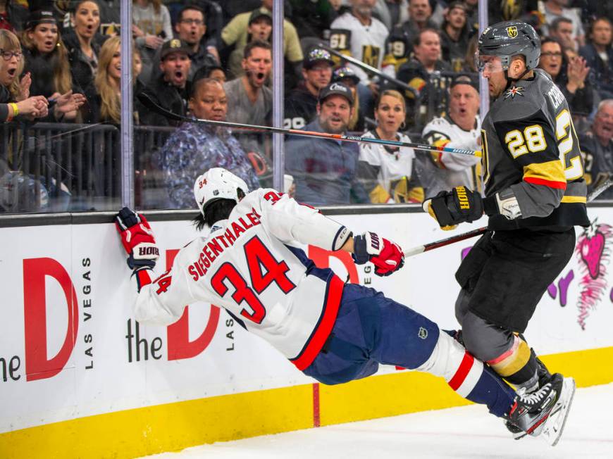 Washington Capitals defenseman Jonas Siegenthaler (34, left) is kicked to the ice after a shot ...