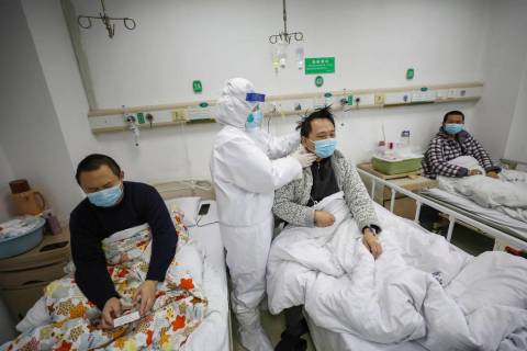 A doctor checks the conditions of a patient in Jinyintan Hospital, designated for critical COVI ...
