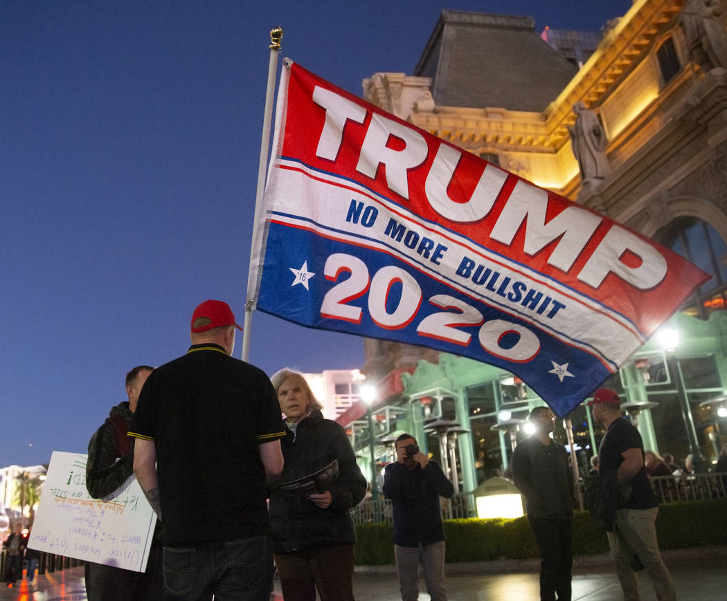 Timothy Lynne, from Henderson, holds a flag supporting President Donald Trump on the Strip outs ...