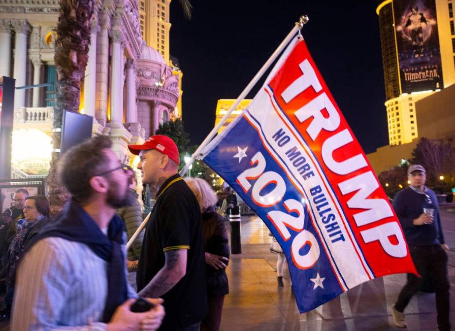 Timothy Lynne, from Henderson, holds a flag supporting President Donald Trump on the Strip outs ...