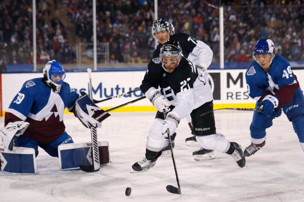 Los Angeles Kings defenseman Alec Martinez, center, looks to redirect the puck, between Colorad ...