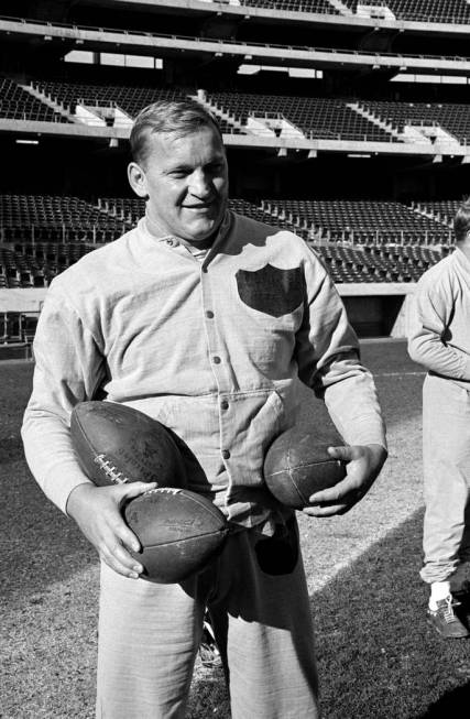 Jim Otto, center for the Oakland Raiders, gets footballs ready for a practice session at Oaklan ...