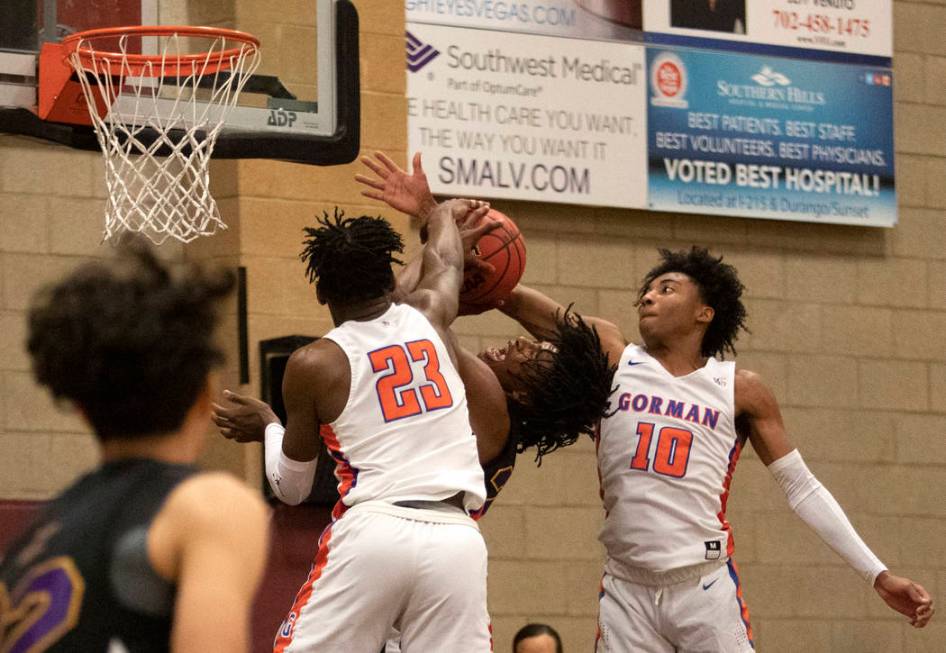 Durango's Anthony Hunter (21) misses a shot as Bishop Gorman's Zaon Collins (10) and Mwani Wilk ...