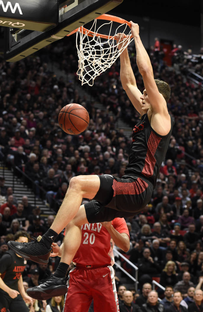 San Diego State forward Yanni Wetzell, top, dunks as UNLV forward Nick Blair (20) looks on duri ...