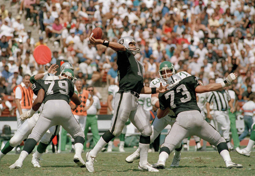 Jim Plunkett, Los Angeles Raiders quarterback winds up to let loose pass to wide receiver Dokie ...