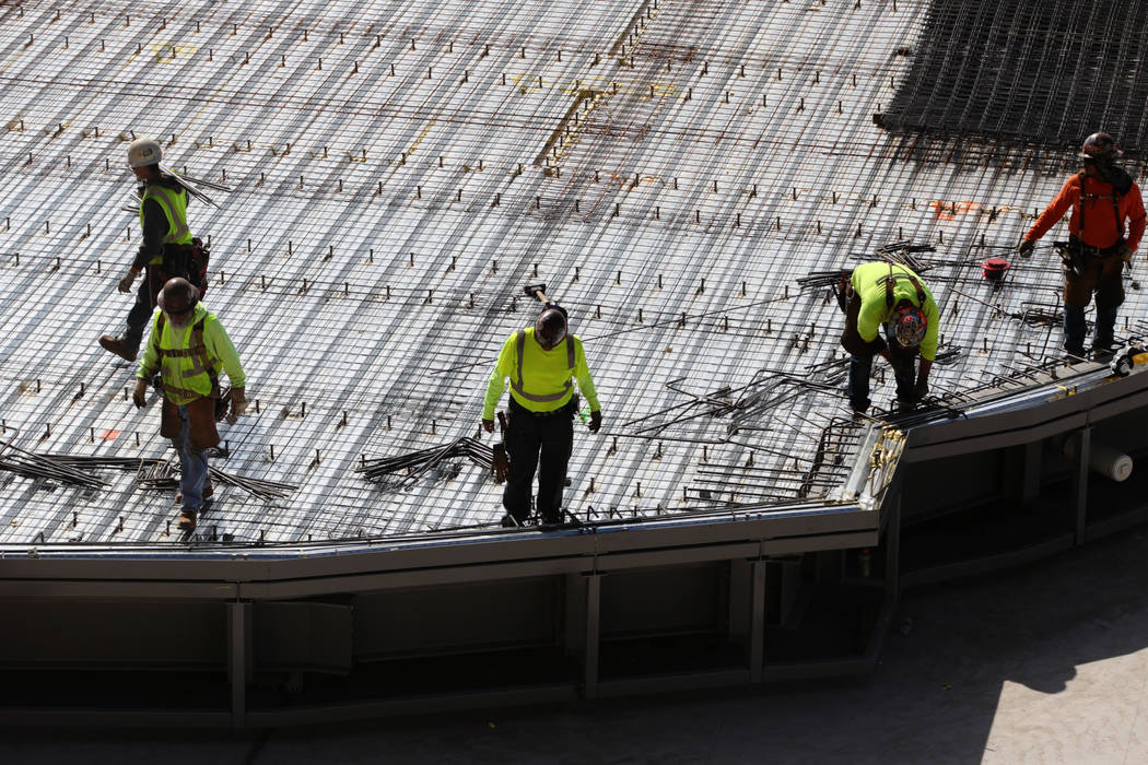 Construction workers prepare a section of the field tray to pour cement at the Raiders Allegian ...