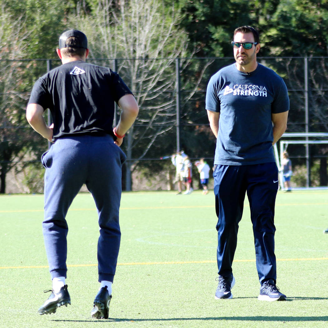 Strength and conditioning coach David Spitz, right, works with football players to prepare them ...