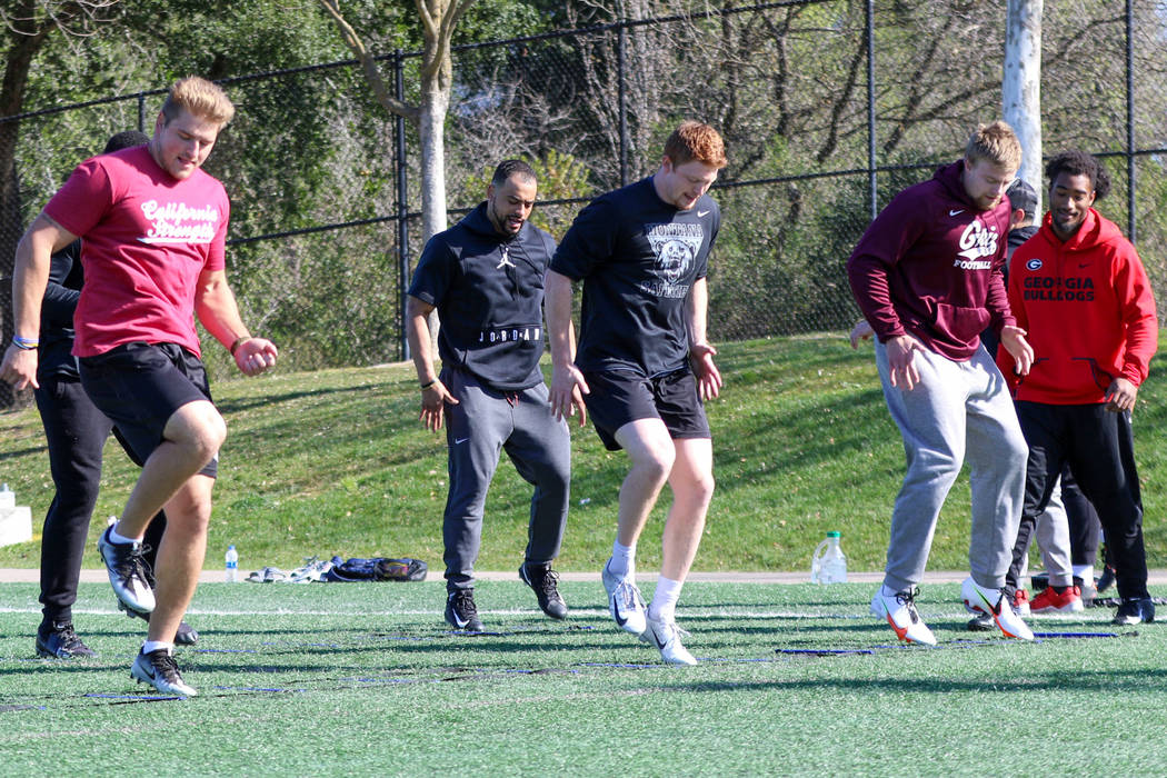 Football players Logan Wilson, from left, Cameron Scarlett, Josh Sandry and Dante Olson run thr ...