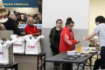 Nation Graca, right, site leader, hands out voting card to Renee Cazares of Las Vegas, during t ...