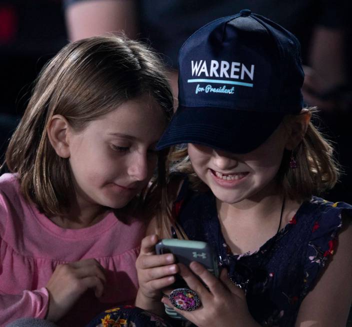 Haylie Bakst, 7, left, and her friend Mia Voos, 7, giggle at a cell phone before Sen. Elizabeth ...