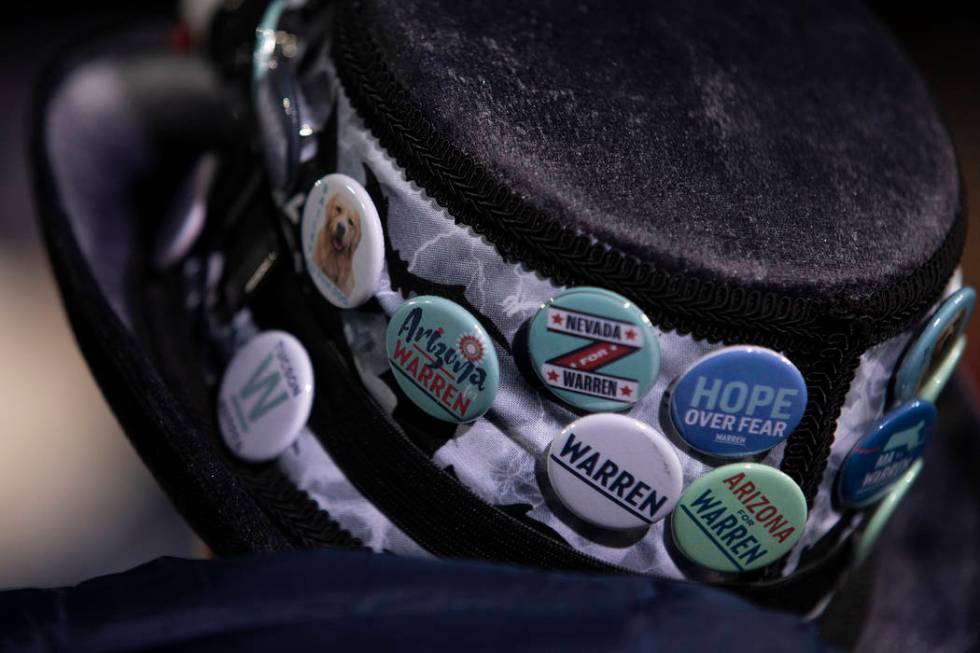 An Elizabeth Warren supporter wears a campaign button clad hat at the "Get Out the Caucus ...