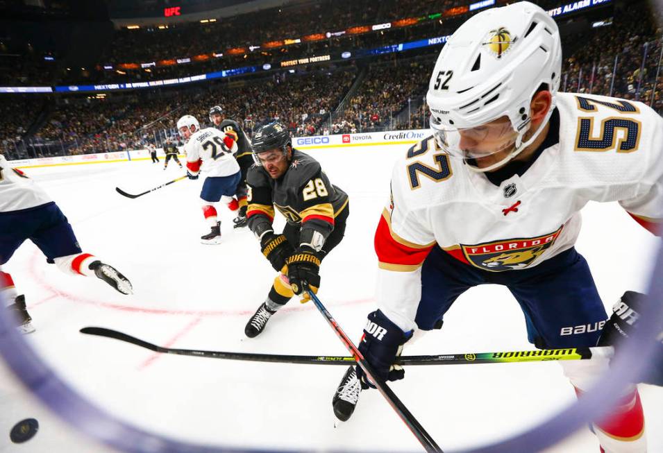 Golden Knights' William Carrier (28) and Florida Panthers' MacKenzie Weegar (52) battle for the ...