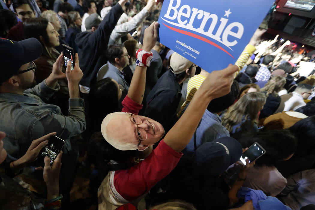 Michelle Nicoleq wears a Bernie Sanders mask as she and other supporters cheer for Democratic p ...