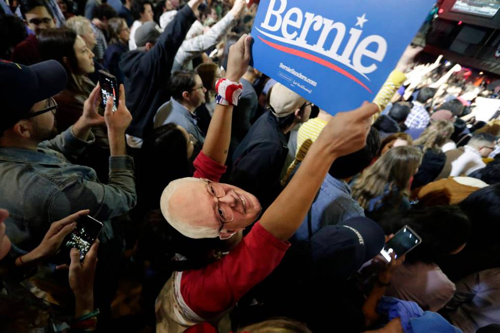 Michelle Nicoleq wears a Bernie Sanders mask as she and other supporters cheer for Democratic p ...