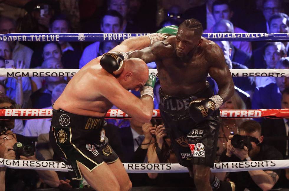 Deontay Wilder, right, connects with a right hook against Tyson Fury in the fourth round during ...