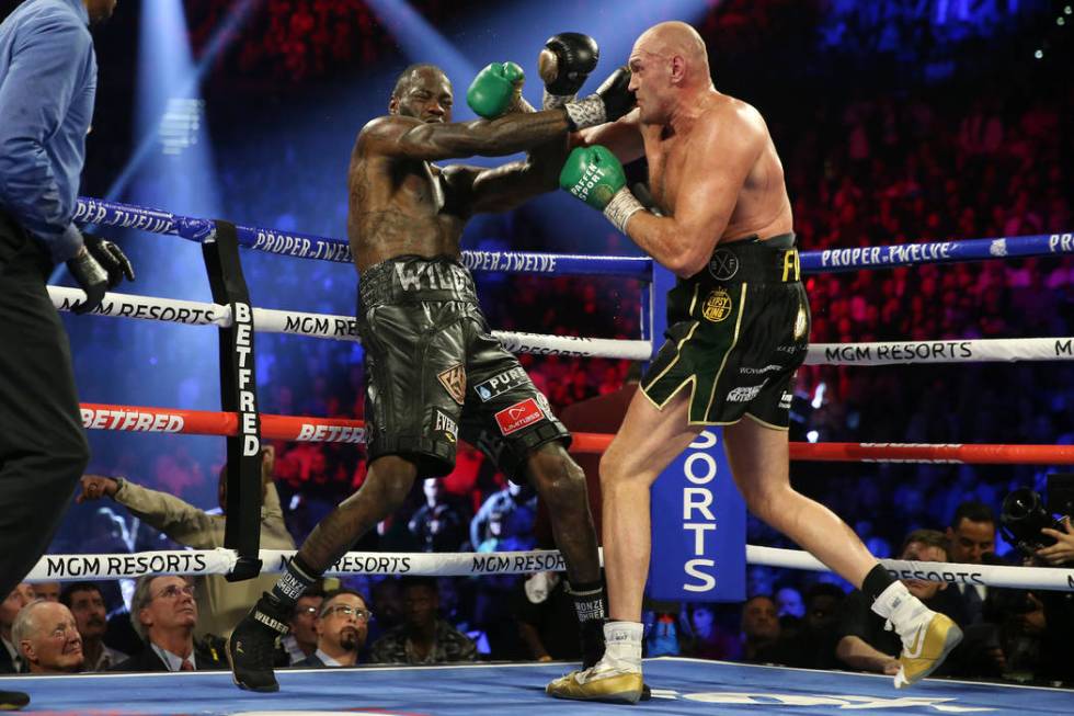 Tyson Fury, right, connects a punch against Deontay Wilder in round 5 of the WBC world heavywei ...