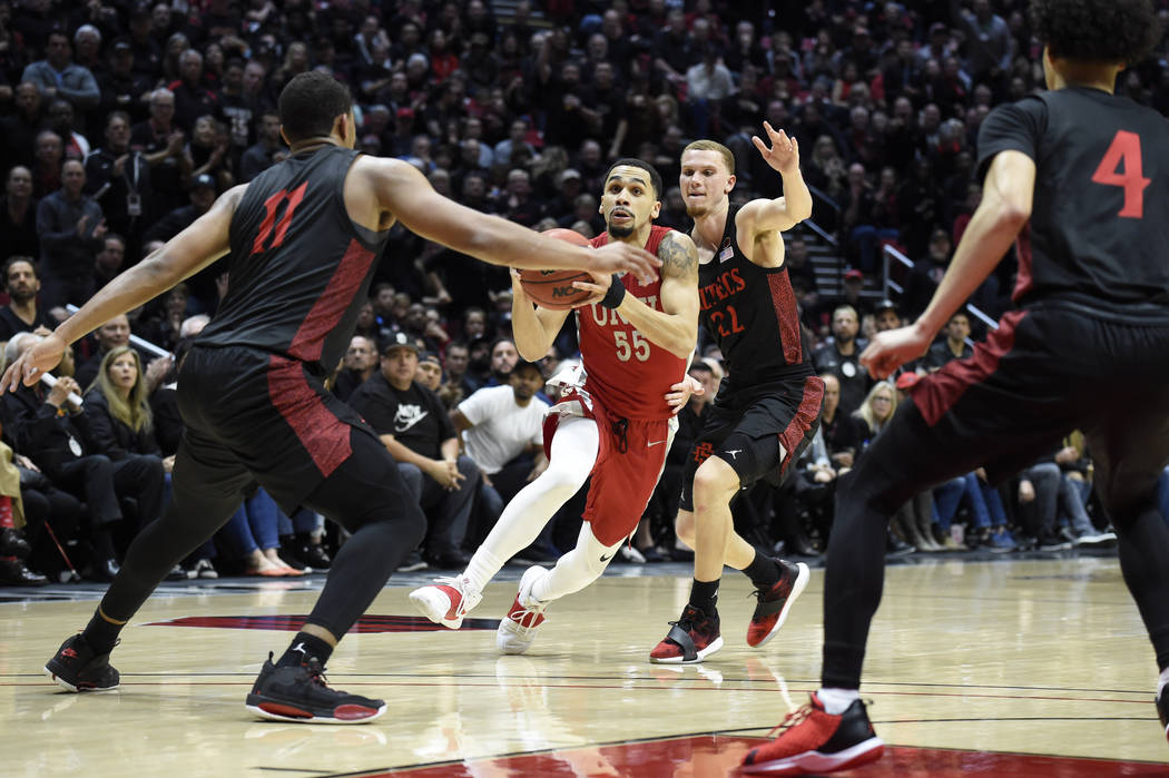 UNLV guard Elijah Mitrou-Long (55) drives against San Diego State forward Matt Mitchell (11), M ...