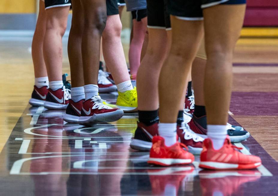 Desert Oasis girl's basketball team players stand on the base line and listen to instructions b ...