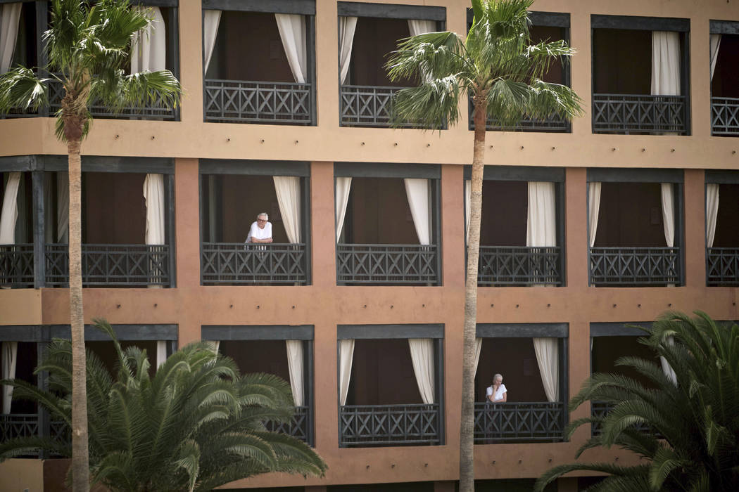 People stand at their balconies at the H10 Costa Adeje Palace hotel in Tenerife, Canary Island, ...