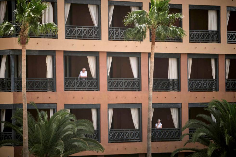 People stand at their balconies at the H10 Costa Adeje Palace hotel in Tenerife, Canary Island, ...
