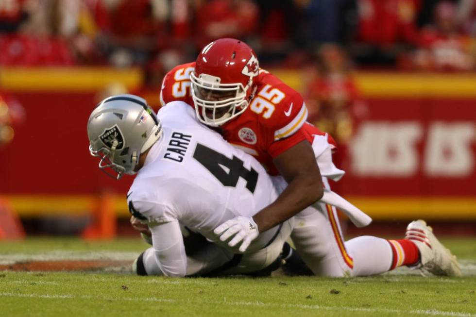 Oakland Raiders quarterback Derek Carr (4) is sacked by Kansas City Chiefs defensive end Chris ...