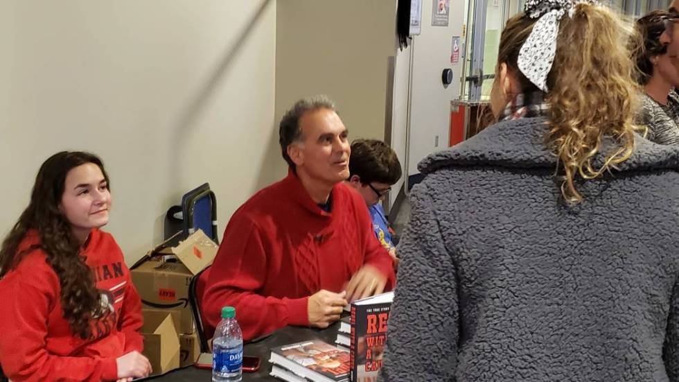 Danny Tarkanian signs copies of his book, "Rebel with a Cause," in the concourse of the Thomas ...