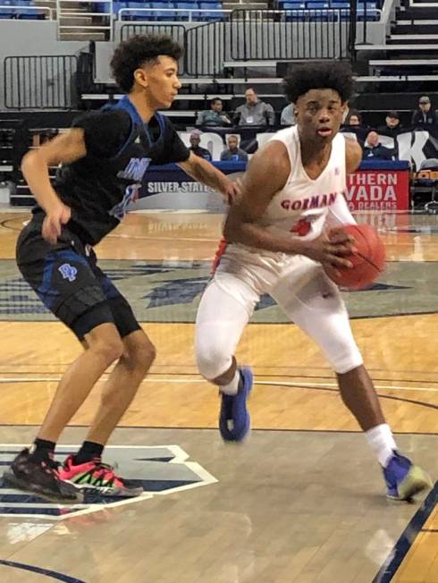 Bishop Gorman's Jonathan Braggs (4) drives to the basket against Desert Pines' Milos Uzan in th ...