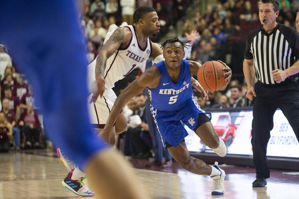 Texas A&M guard Savion Flagg (1) tries to steal the ball from Kentucky guard Immanuel Quick ...